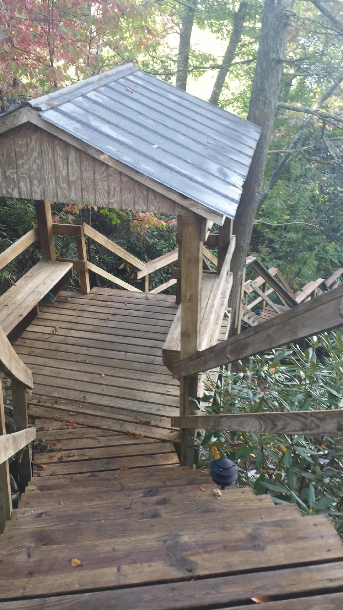 Metal roofed shelter over wooden steps on a wooded walkway — Skylight Repair & Installation work by our crew in Hudson
